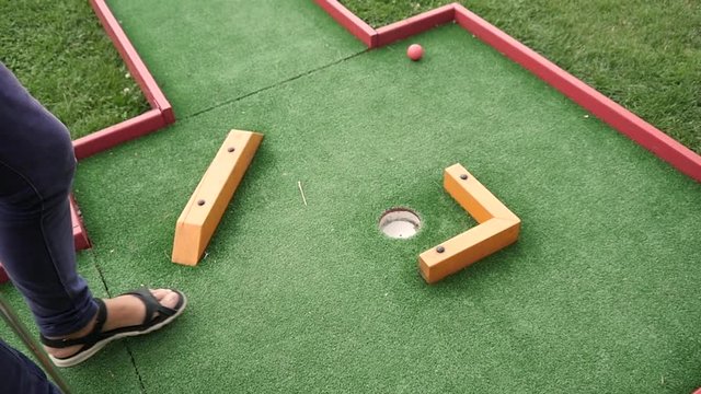 Young woman play mini golf in park club amuse having fun in slow motion