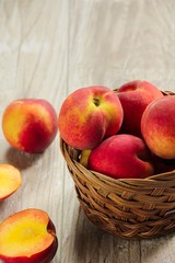 Naklejka na ściany i meble Fresh Peaches in a a basket / Summer Fruits