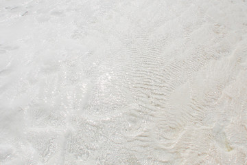 snow-white ribbed texture of natural travertine rock, washed by clear waters, close-up