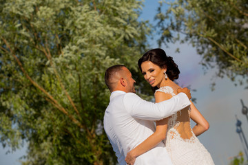 Beautiful Romantic Wedding Couple Of Newlyweds Hugging In Park On Sunset