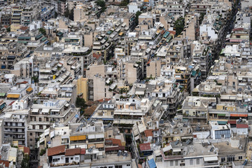 Fototapeta premium Greece, Athens: Skyline with mass of houses, buildings, apartments, rooftops in the city center of Greek capital - concept urban development town planning structure living condition.