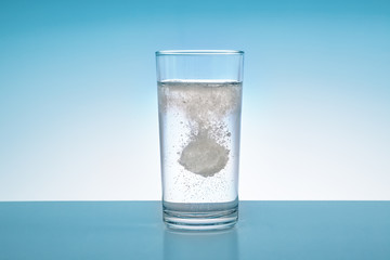 Brausetablette fällt in ein  Wasserglas
