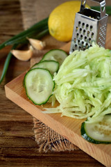 Grated cucumber on a wooden board. Ingredient for a meal