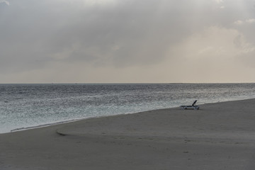 Nice sunset time with beach chair on coast