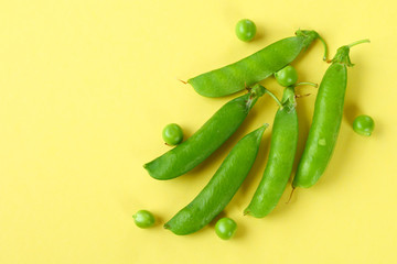 Peas, pods, leaves and pea flowers on a light pastel background. Floral layout.