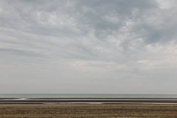 Fototapeta na wymiar tranquil shot of sandy seashore on cloudy day, Bray Dunes, France