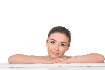 Fototapeta premium Beautiful young woman with silky skin after spa treatment lying on towel against white background