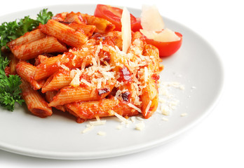 Plate with delicious penne pasta and garnish on white background