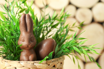 Basket with chocolate Easter bunny and egg on blurred background