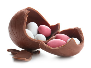 Candies in broken chocolate Easter egg on white background