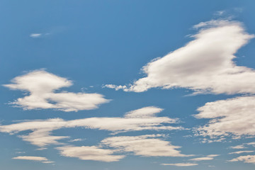 Naklejka na ściany i meble Unusual shape small fluffy clouds in the blue sky