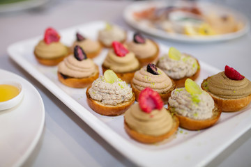 Wedding appetizer. Fruit dessert sandwiches served on the table.
