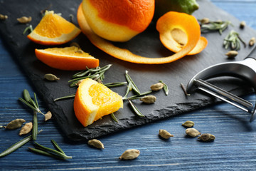 Slate plate with ripe citrus fruit on wooden table