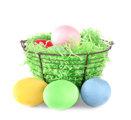 Basket with colorful Easter eggs on white background