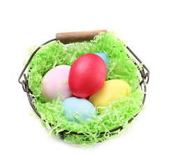Basket with colorful Easter eggs on white background
