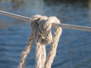 Clove hitch against smoothly rippled lake water backround around a reeling to keep a fender on a...