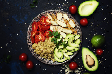 Fototapeta na wymiar Healthy food, avocado, quinoa, chicken and tomatoes on plate, top view