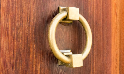 Close-up of typical Catalan brass door knocker married with veined wood with deep tones