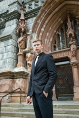 Fototapeta na wymiar Handsome young man in trendy black suit and tie posing