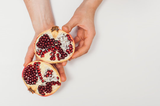 hand holding pomegranate isolated on white background