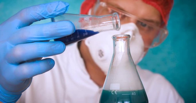 The alchemist, holds the flasks, tests the test tubes with a test of different compositions, in a white coat, a respirator, goggles, rubber white gloves, a green background.