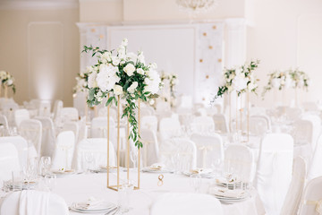 Wedding in a tent. Decoration of the hall. Green tablecloths, beautiful decor and dishes.
