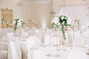 Wedding in a tent. Decoration of the hall. Green tablecloths, beautiful decor and dishes.