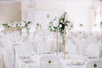Wedding in a tent. Decoration of the hall. Green tablecloths, beautiful decor and dishes.