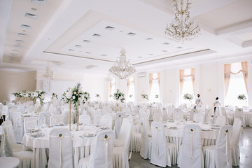 Wedding in a tent. Decoration of the hall. Green tablecloths, beautiful decor and dishes.
