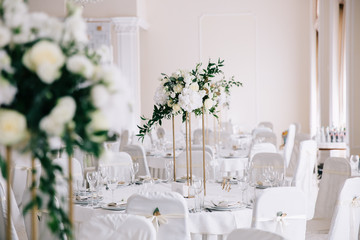 Wedding in a tent. Decoration of the hall. Green tablecloths, beautiful decor and dishes.