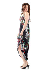 young beautiful woman in sundress with colorful flower pattern, playfully exposing the leg