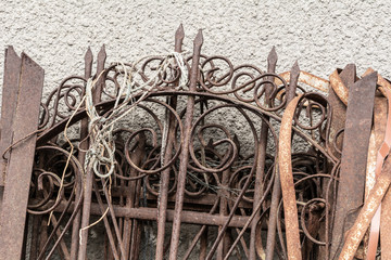 Rusty forged fence near the cement wall