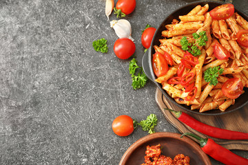 Composition with tasty penne pasta on grey background