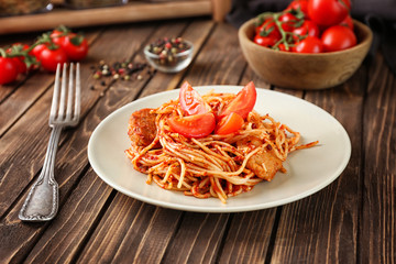 Plate of delicious pasta with tomato sauce on table