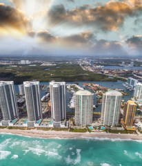 Aerial view of North Miami Beach skyscrapers with sun and clouds