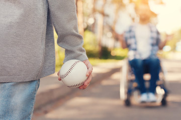 Catch it. Tennis ball being in hands of a nice pleasant child while being ready for a throw