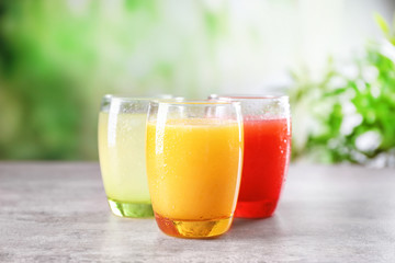 Glasses with different citrus juices on table