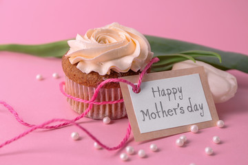 Tasty cupcake, tulip and card with words HAPPY MOTHER'S DAY on color background