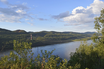 Fototapeta premium View of the river, wooded hills and wires over the river.