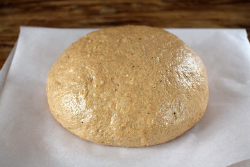 Fototapeta na wymiar Rye dough is prepared for baking on a piece of parchment