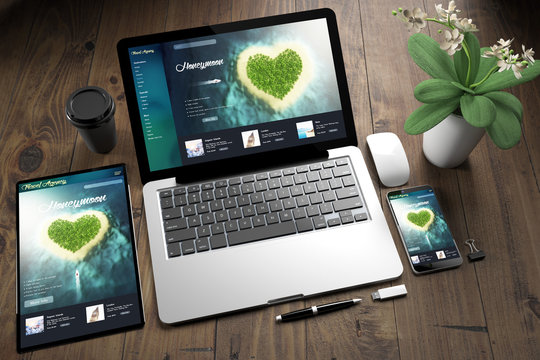 tablet, laptop and mobile phone over wooden desktop showing honeymoon website
