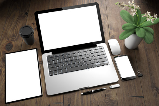 tablet, laptop and mobile phone over wooden desktop