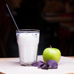 Ayran - liquid drink made from yogurt in ransparent glass cup and green apple