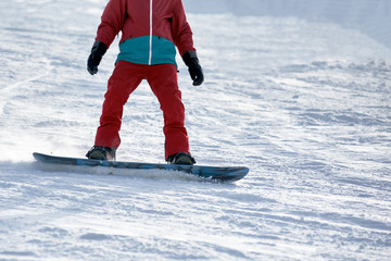 Closeup photo of snowboarder riding on board on winter resort