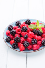 Fresh raspberries in a plate on a  vintage background.