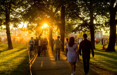 At sunset, people spend the weekend with the whole family in the park. Sunset family  weekend.