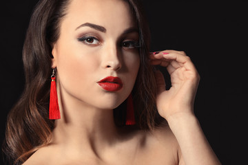 Fototapeta na wymiar Portrait of young woman with beautiful professional makeup on dark background