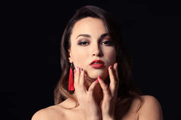 Portrait of young woman with beautiful professional makeup on dark background