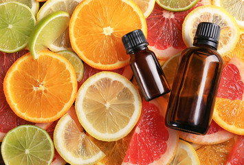Bottles of essential oil on citrus slices