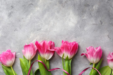 Beautiful fresh tulips on grey textured background